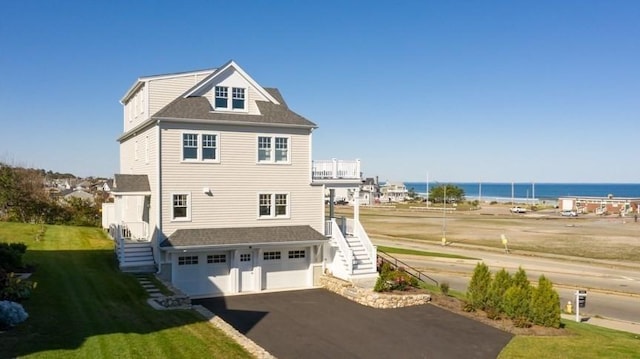 rear view of house featuring a garage and a water view