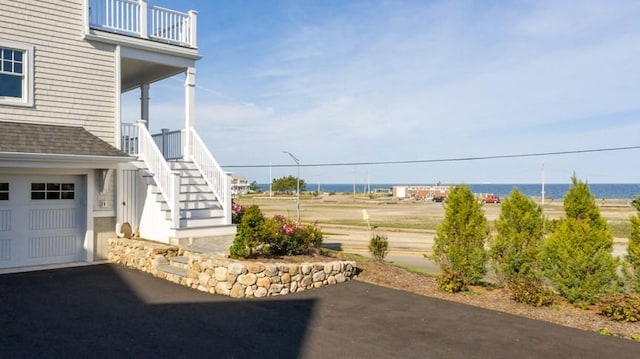 view of yard featuring a water view and a garage