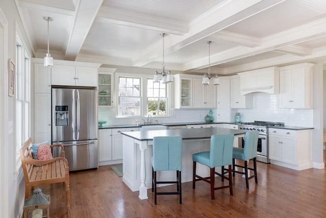 kitchen with white cabinets, stainless steel appliances, a kitchen island, and a breakfast bar area