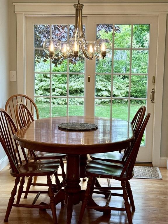 dining area with a chandelier, light wood-style flooring, and baseboards