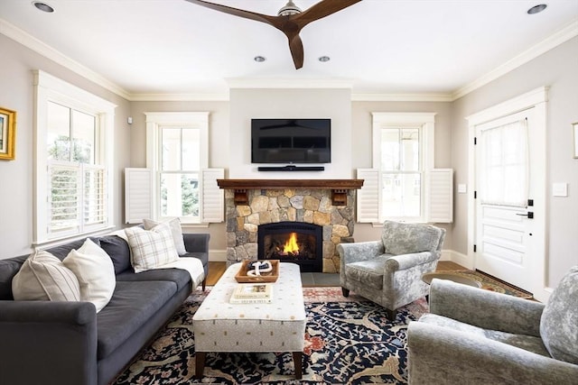 living room with a fireplace, wood-type flooring, ceiling fan, and crown molding