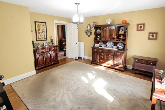 dining area with an inviting chandelier, radiator heating unit, and hardwood / wood-style floors