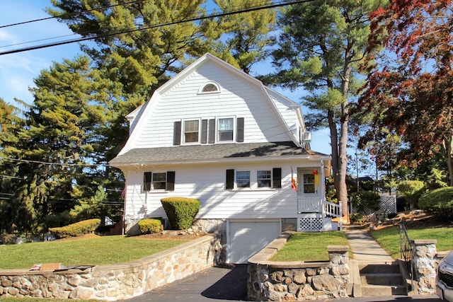 view of front of home with a front yard and a garage