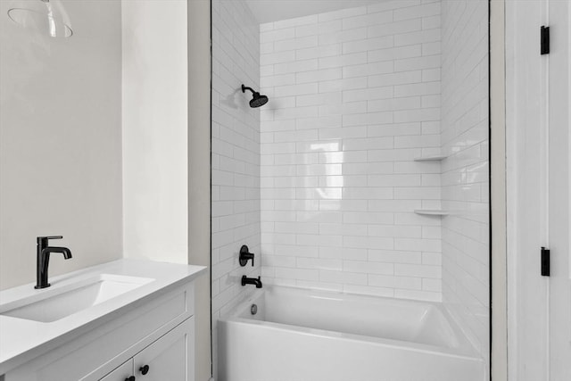 bathroom featuring tiled shower / bath and vanity