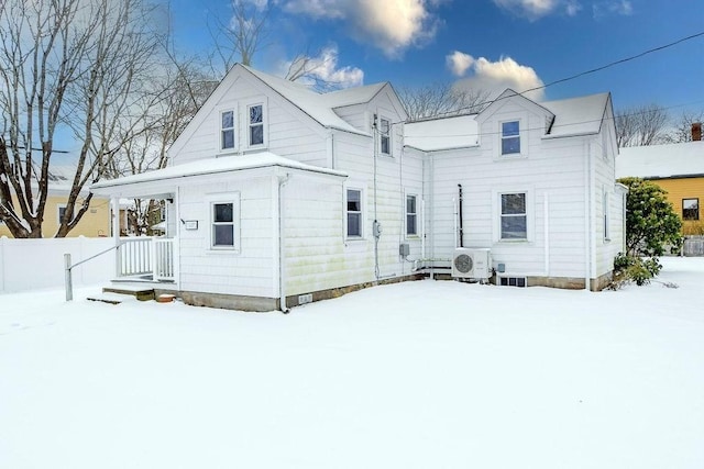 snow covered back of property featuring ac unit