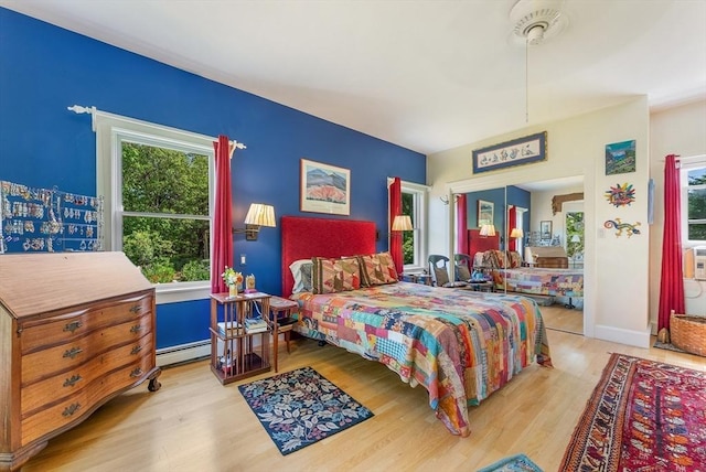 56 Bridle Path, Tisbury, MA 02567 - bedroom with a baseboard heating unit, multiple windows, and wood finished floors