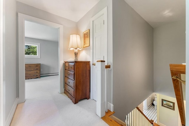 56 Bridle Path, Tisbury, MA 02567 - hall with a baseboard heating unit, light colored carpet, an upstairs landing, and baseboards
