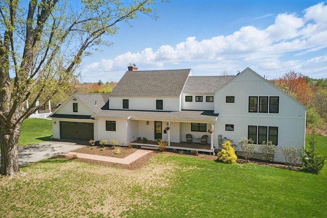 back of property featuring a chimney, driveway, a yard, a porch, and roof with shingles