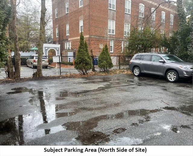 view of vehicle parking with fence