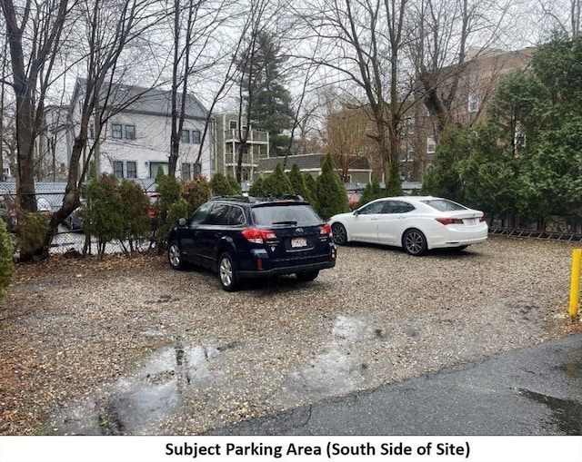 view of vehicle parking with fence