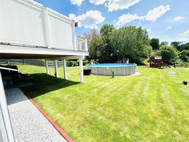 38 Thayer Ave, Whitman, MA 02382 - view of grassy yard with an outdoor pool, a playground, and a deck