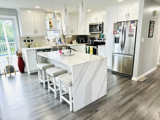 38 Thayer Ave, Whitman, MA 02382 - kitchen with stainless steel appliances, dark wood-style floors, tasteful backsplash, white cabinets, and a center island