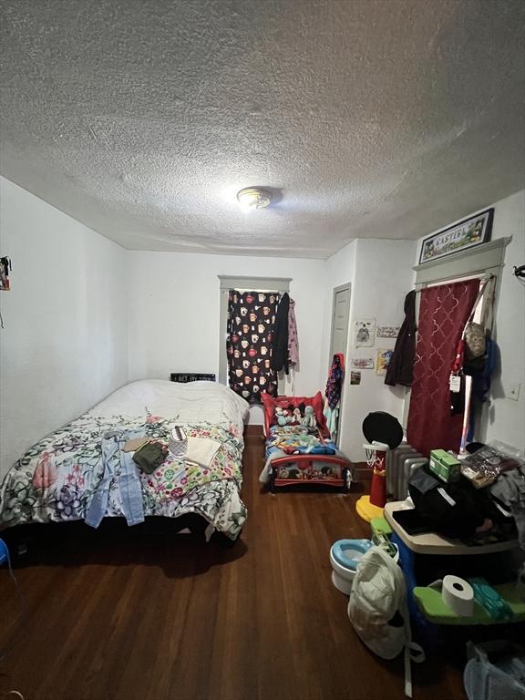 bedroom featuring a textured ceiling and wood finished floors