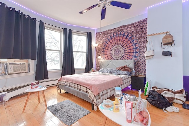 bedroom with cooling unit, a baseboard radiator, ceiling fan, and hardwood / wood-style flooring