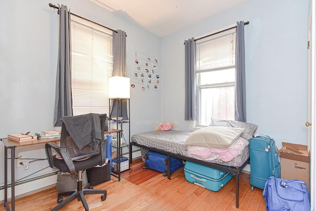 bedroom with baseboard heating and wood-type flooring