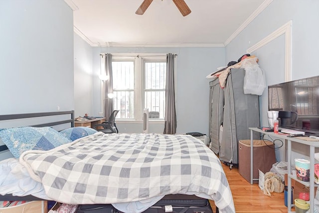 bedroom with crown molding, light wood-type flooring, and a ceiling fan