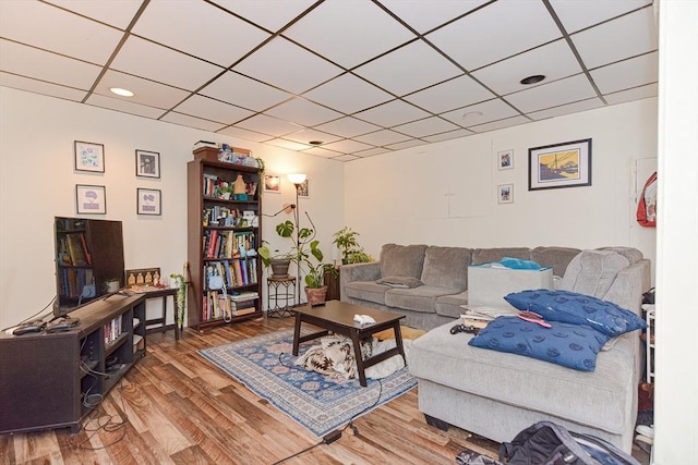 living room featuring wood finished floors and a paneled ceiling