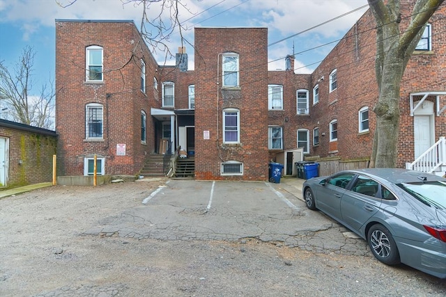 exterior space featuring uncovered parking and brick siding