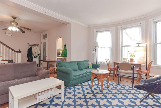 living room with stairway, wood finished floors, arched walkways, and ornamental molding