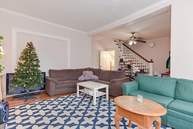 living area featuring crown molding, stairs, a ceiling fan, and wood finished floors