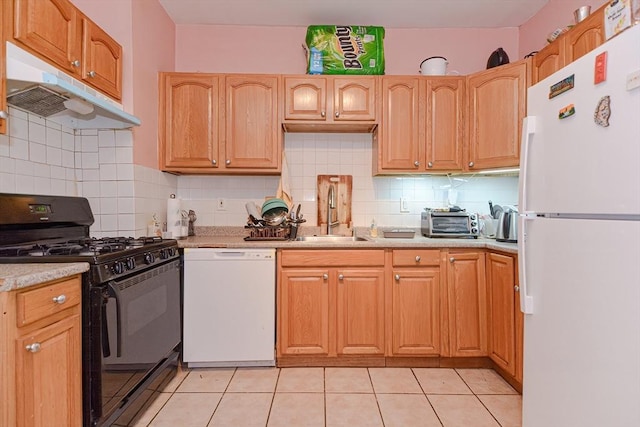 kitchen featuring under cabinet range hood, light countertops, decorative backsplash, white appliances, and a sink