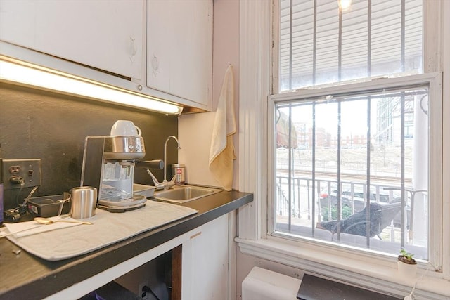 kitchen featuring a sink, a wealth of natural light, and white cabinets