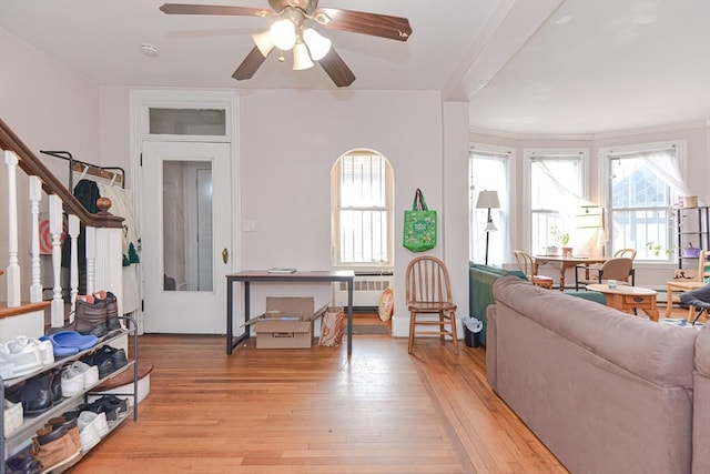 living area featuring stairway, radiator, and light wood-style floors