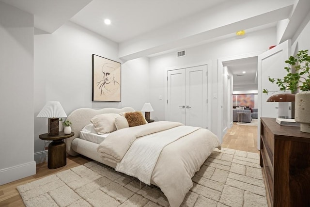 bedroom with visible vents, recessed lighting, light wood finished floors, and a closet
