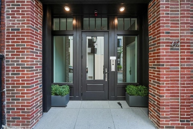property entrance featuring french doors and brick siding