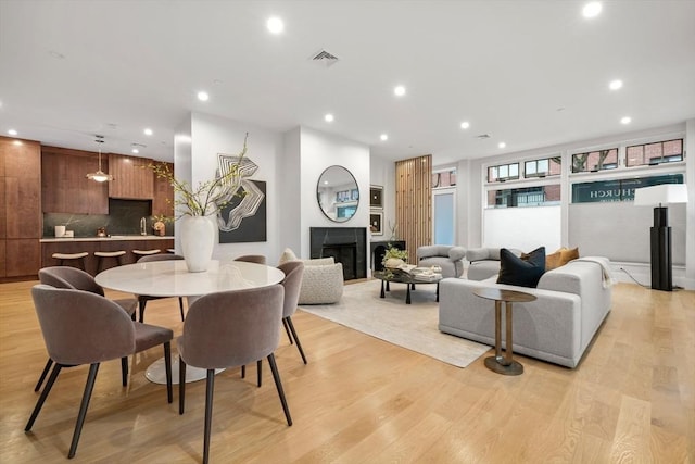 dining room with visible vents, recessed lighting, light wood-style flooring, and a fireplace