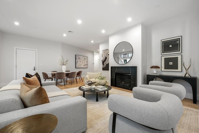 living area with light wood-style floors, a fireplace, recessed lighting, and visible vents
