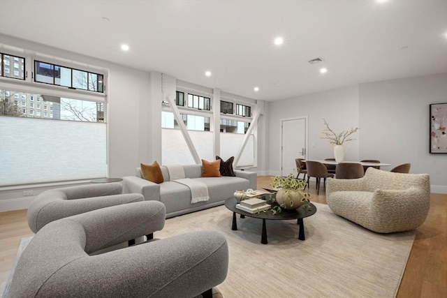 living room with recessed lighting, baseboards, light wood finished floors, and visible vents
