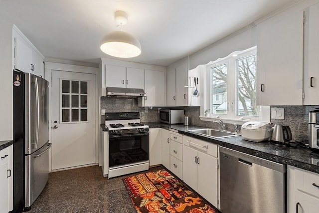 kitchen with stainless steel appliances, dark countertops, granite finish floor, a sink, and under cabinet range hood