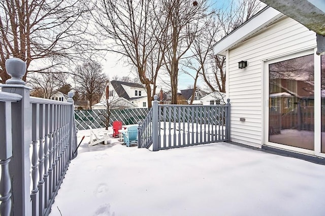 snow covered patio featuring fence