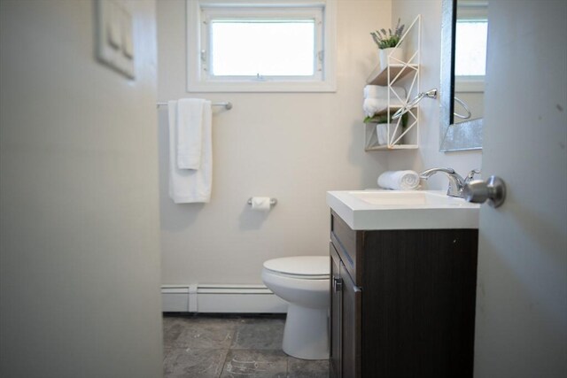 bathroom featuring vanity, a baseboard heating unit, and toilet