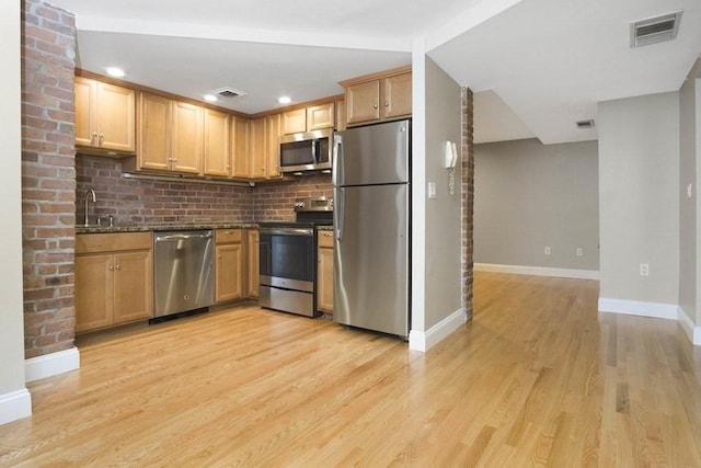 kitchen featuring light wood-style floors, stainless steel appliances, baseboards, and visible vents