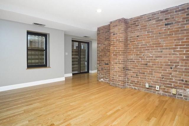 unfurnished room featuring visible vents, wood finished floors, and baseboards