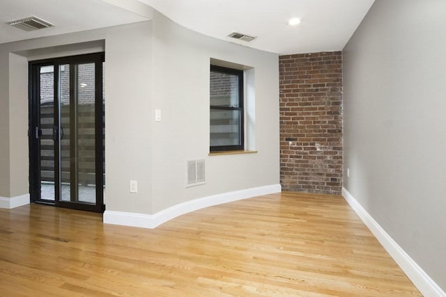 unfurnished room featuring visible vents, wood finished floors, and baseboards