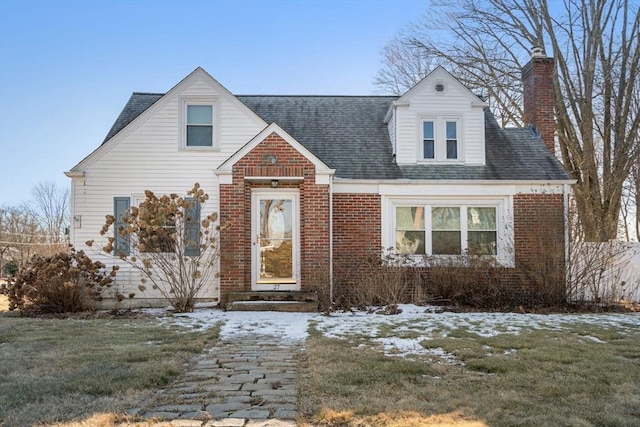 cape cod-style house with a lawn