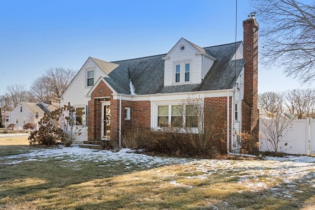 cape cod-style house with a lawn