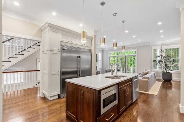 33 Winthrop Unit 1, Brookline, MA 02445 - kitchen featuring built in appliances, a sink, dark wood finished floors, light countertops, and crown molding