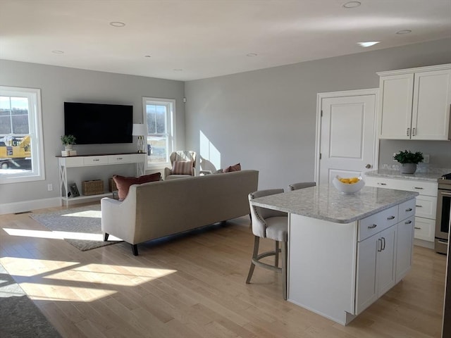 living room featuring a wealth of natural light and light hardwood / wood-style flooring