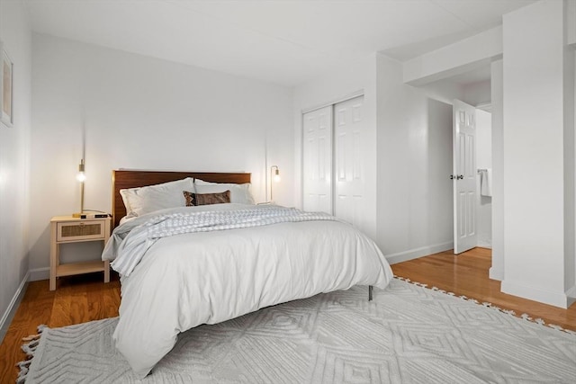 bedroom with wood-type flooring and a closet