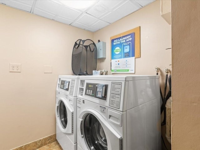 laundry area featuring washer and clothes dryer and light tile patterned floors