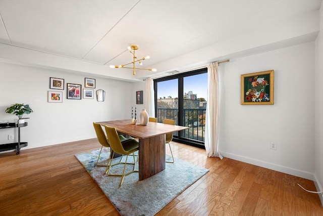 dining area featuring light wood-type flooring and an inviting chandelier