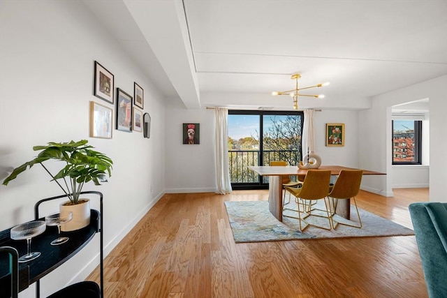 dining room with light wood-type flooring and a chandelier