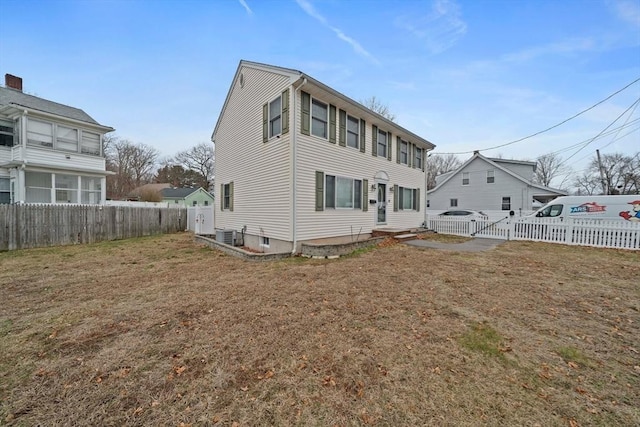 back of property featuring a gate, a yard, and fence