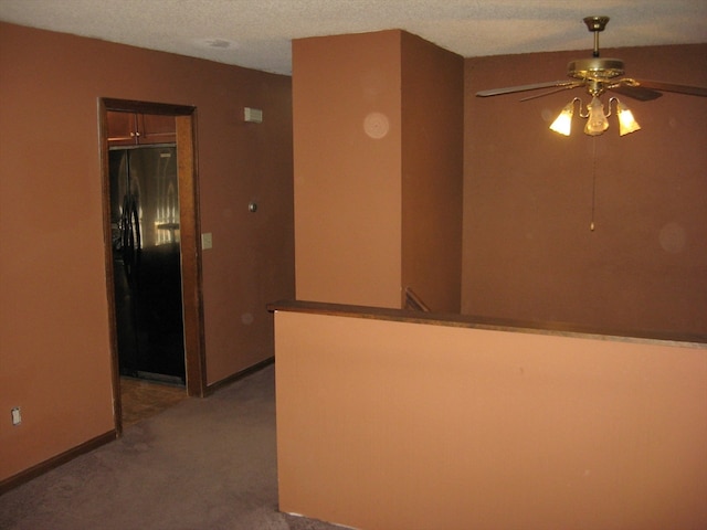 carpeted empty room with a textured ceiling and ceiling fan