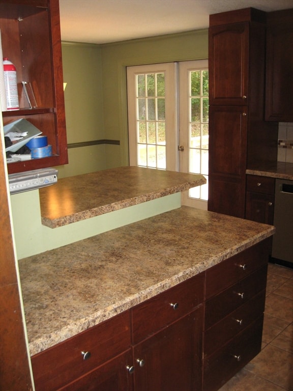 kitchen featuring dark tile patterned flooring, dishwasher, backsplash, and french doors