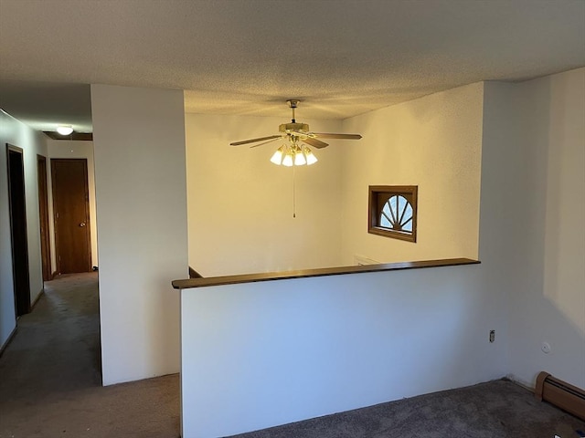 spare room featuring carpet flooring, ceiling fan, a baseboard radiator, and a textured ceiling